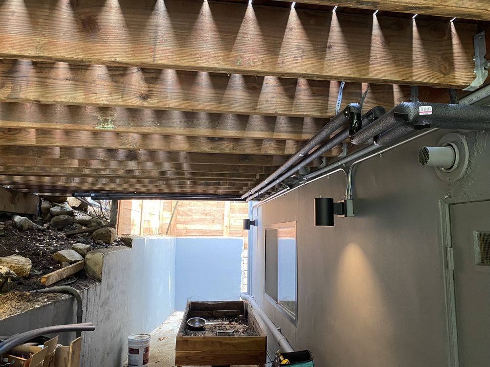 Outdoor shower finish with insulated plumbing line under the deck