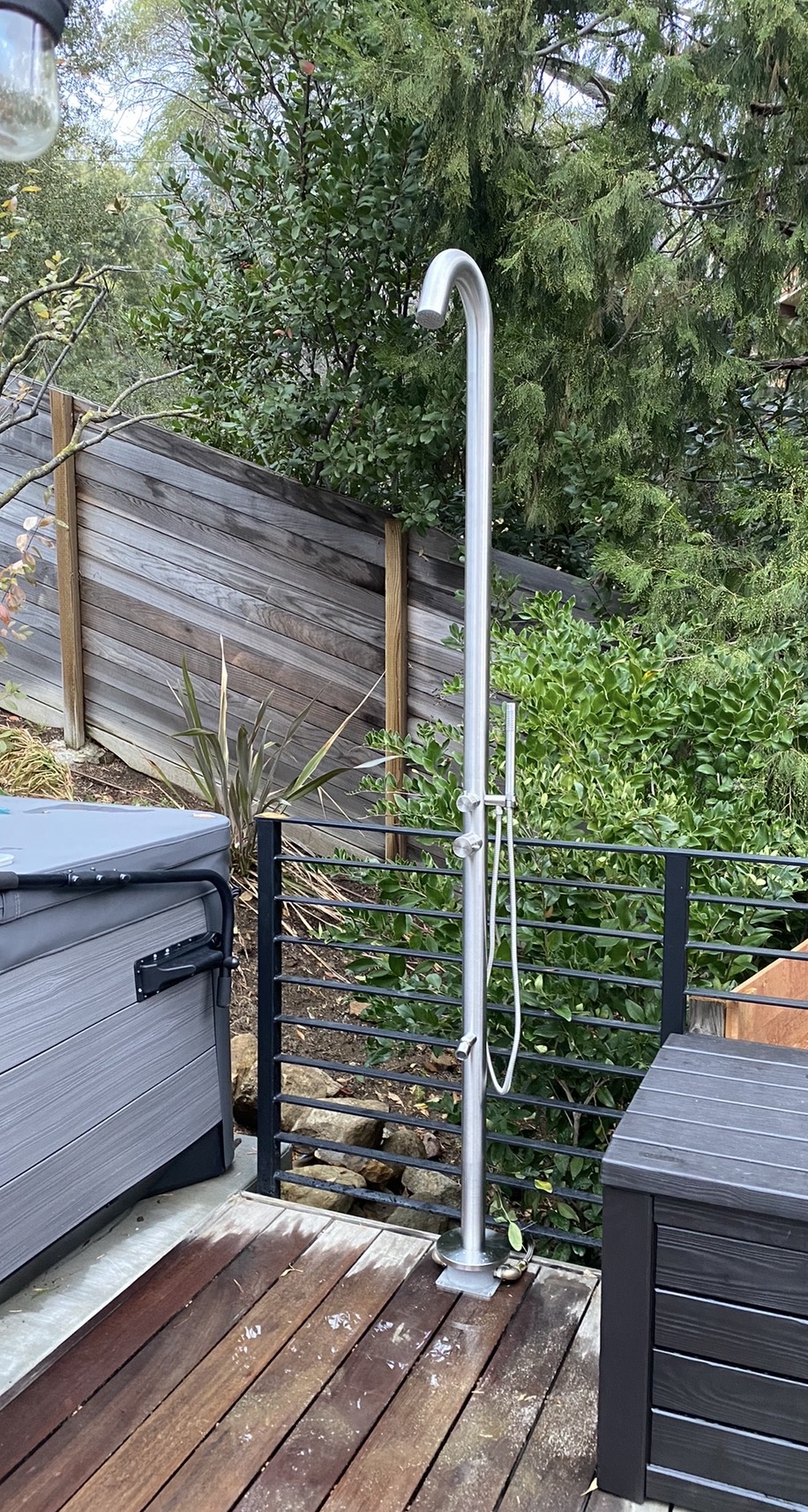 Freestanding outdoor shower installed beside a hot tub