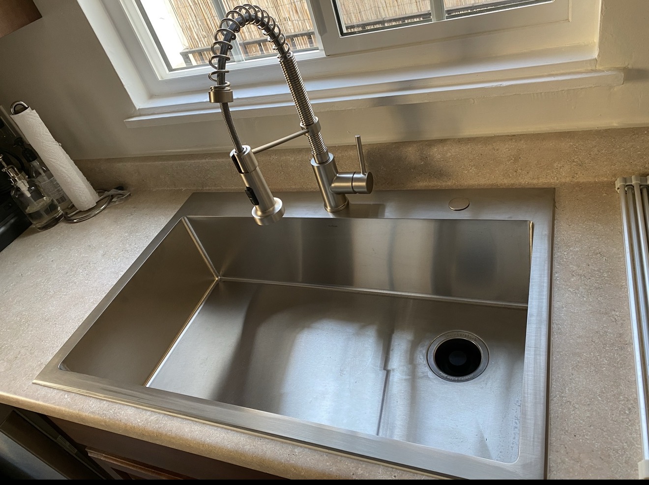 Updated residential sink on the same white tile counter after the swap